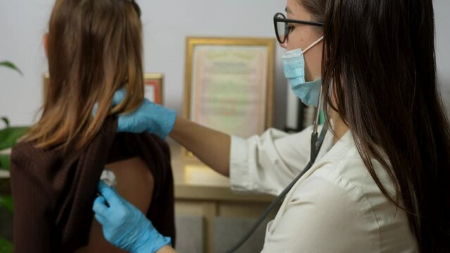 Woman doctor pediatrician hold stethoscope exam little child girl