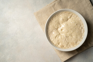Top view sourdough starter in a bowl. Copy space. Home baking, wild east, fermented food.