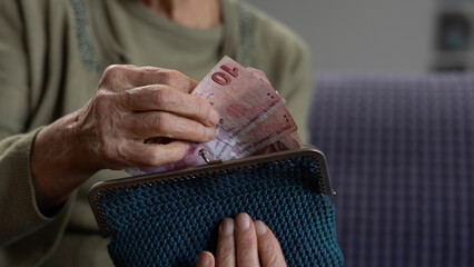 old woman counting money on hand