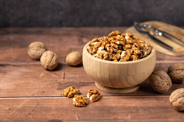 Walnuts in a wooden bowl. Shelled, dried seeds of walnuts in wooden bowl. Copy space.
