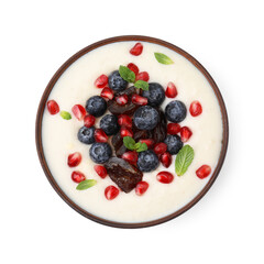 Delicious semolina pudding with blueberries, pomegranate, dates and mint in bowl isolated on white, top view