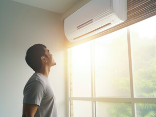 Happy man under air conditioner feeling relax at home	