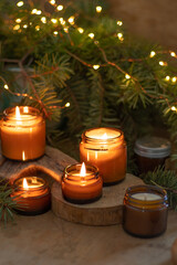 Soy candles burn in glass jars. Comfort at home. Candle in a brown jar. Scent and light. Scented handmade candle. Aroma therapy. Christmas tree and winter mood. Cozy home decor. Festive decoration.