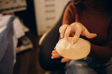 Plastic Cosmetic Surgeon Shows Female Patient Breast Implant Samples for Her Future Surgery....