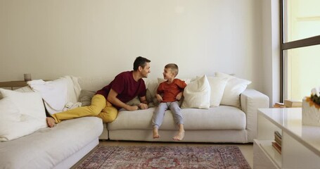 Active vivacious father and little 7s son have fun, play together in living room, catching up, running and flopped down, jumping on comfortable sofa, enjoy playtime on leisure. Games with kids at home - Powered by Adobe