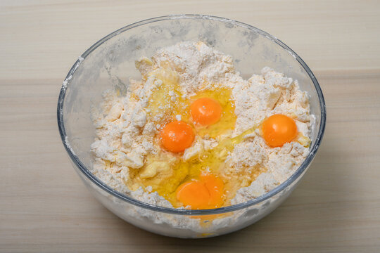 Rozbite jajka w misce z mąką składniki na kruche ciasto