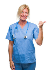 Middle age blonde nurse surgeon doctor woman over isolated background smiling with happy face...