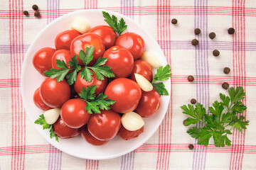 Image of red pizzcled canned tomatoes on a plate. Image of red canned tomatoes on a white plate