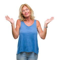 Fototapeta na wymiar Middle age blonde woman over isolated background clueless and confused expression with arms and hands raised. Doubt concept.