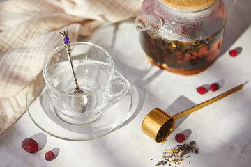 Fruit and berry tea. Preparation. Empty glass teapot and cup on the table