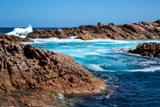 Ocean surging among rugged coastal rocks.