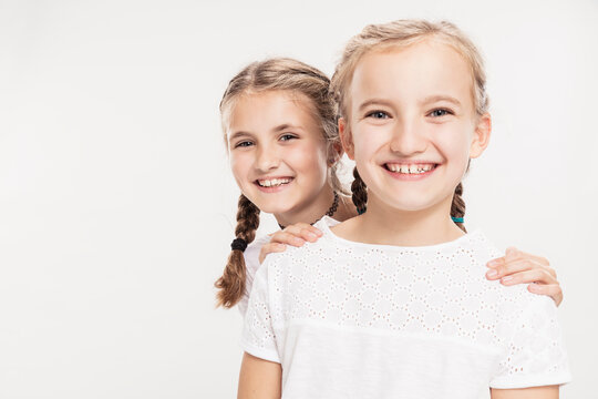 Studioportrait zwei Mädchen lachend mit Zahnlücken