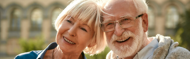 Happy senior couple smiling while spending time together outdoors - Powered by Adobe