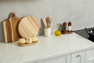 Wooden cutting boards and other cooking utensils on white countertop in kitchen