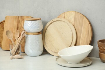 DIfferent wooden cutting boards and other cooking utensils on white countertop in kitchen