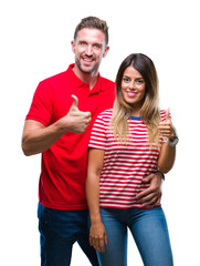 Young couple in love over isolated background doing happy thumbs up gesture with hand. Approving...