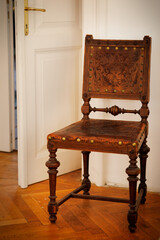 A Baroque chair. The upholstery is made of genuine brown leather with embossed and floral pattern