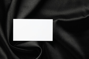 Blank business card on black fabric, top view. Mockup for design