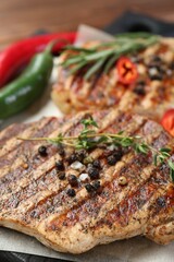 Delicious grilled pork steaks with spices on table, closeup