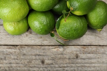 Fresh limes on wooden table, top view. Space for text