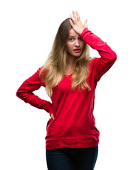 Obraz na płótnie Canvas Young beautiful blonde woman wearing red sweater over isolated background surprised with hand on head for mistake, remember error. Forgot, bad memory concept.