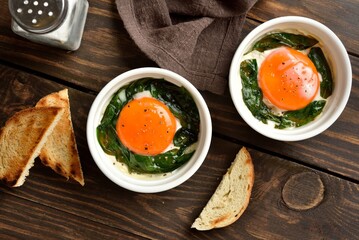 Baked eggs with vibrant orange yolks and spinach