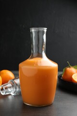 Delicious tangerine liqueur and fresh fruits on grey table