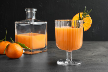 Delicious tangerine liqueur and fresh fruits on grey table