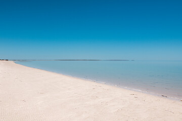 a peaceful beach with white sand and calm blue water