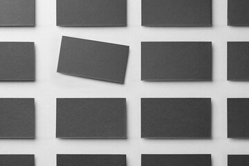 Blank black business cards on light background, flat lay. Mockup for design