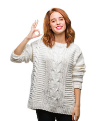 Young beautiful woman over isolated background wearing winter sweater smiling positive doing ok sign with hand and fingers. Successful expression.