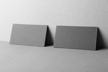 Blank black business cards on grey background. Mockup for design