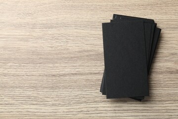 Blank black business cards on wooden table, top view. Mockup for design