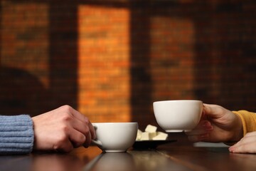Women having coffee break at wooden table in cafe, closeup - Powered by Adobe