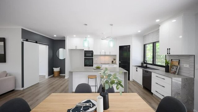 modern black and white open planned kitchen with stone bench tops and elegant pendant lights. Interior design with stylish dining furniture