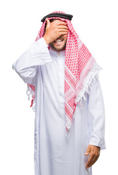 Young handsome man wearing keffiyeh over isolated background smiling and laughing with hand on face covering eyes for surprise. Blind concept.