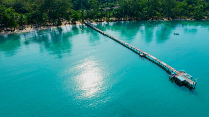 The wooden jetty leads out to the sea with  blue turquoise sea water scene in summer tropical background