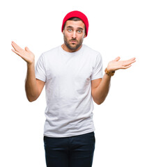 Young handsome man over isolated background clueless and confused expression with arms and hands...