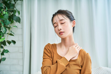 肩こりに苦しむ様子の若い女性