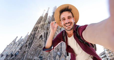 Happy tourist visiting La Sagrada Familia, Barcelona Spain - Smiling man taking a selfie outdoor on...