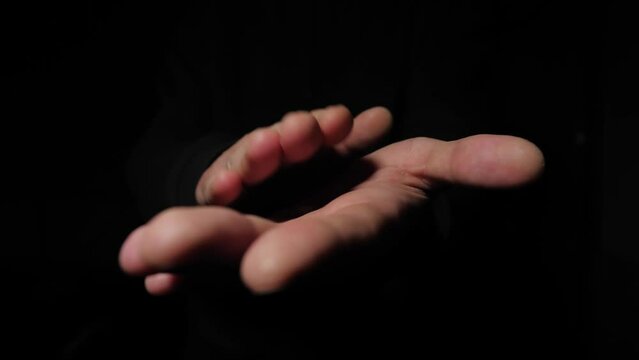 stranger claps his hands on a black background. Close-up of men's hands clapping.