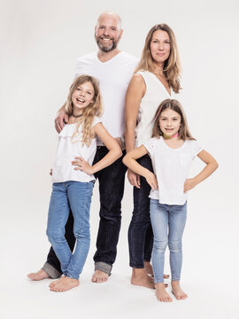 Studioportrait Familie mit zwei Kindern barfuss in Jeans