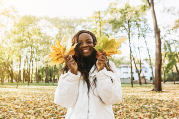 African american woman walking outdoor, portrait of young latin lady in warm sunny autumn park...