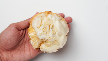 Freshly baked cream puffs or Vanilla eclairs with cream and nuts topping isolated on white background