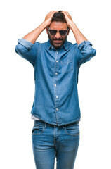 Adult hispanic man wearing sunglasses over isolated background suffering from headache desperate and stressed because pain and migraine. Hands on head.