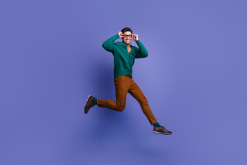 Fototapeta na wymiar Photo of successful positive man wear trendy clothes hurrying store mall buy eyeglasses optics isolated on violet color background