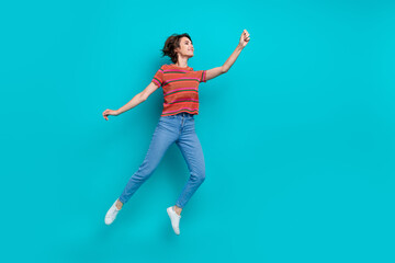 Fototapeta na wymiar Full length photo of charming funky girl wear trendy outfit hold announcement empty space isolated on cyan color background