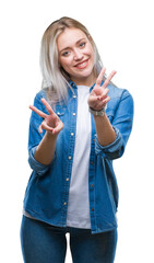 Obraz premium Young blonde woman over isolated background smiling looking to the camera showing fingers doing victory sign. Number two.