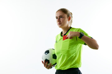 Young woman, female soccer referee holding ball, stopping game and showing red card against white...