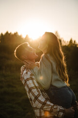 Young man spins woman, walking spending time together in nature. Couple hugging and smiling in...
